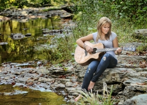 Katie O. posed with her guitar on a creek's edge